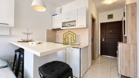 Small white kitchen with a breakfast bar and a bar stool. - image 7
