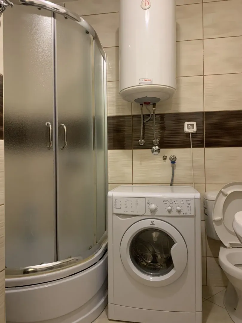 Bathroom with a shower cabin and washing machine.