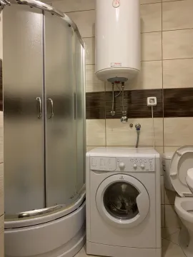 Bathroom with a shower cabin and washing machine. - image 2