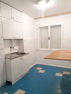 Smaller kitchen with white cabinets, a sink, and a window. - image 7
