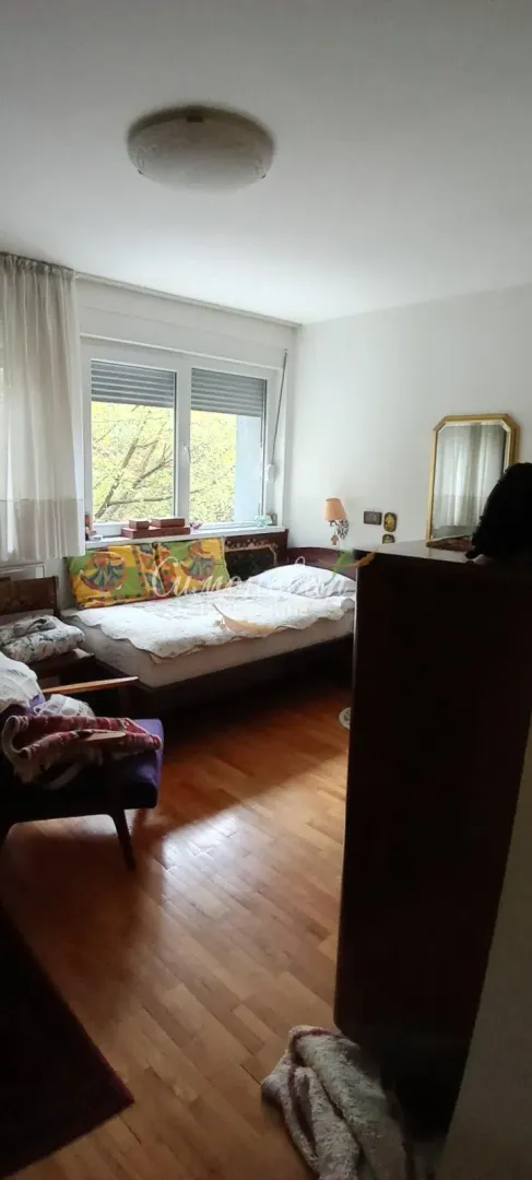 Nameštena spavaća soba sa krevetom i prozorom.