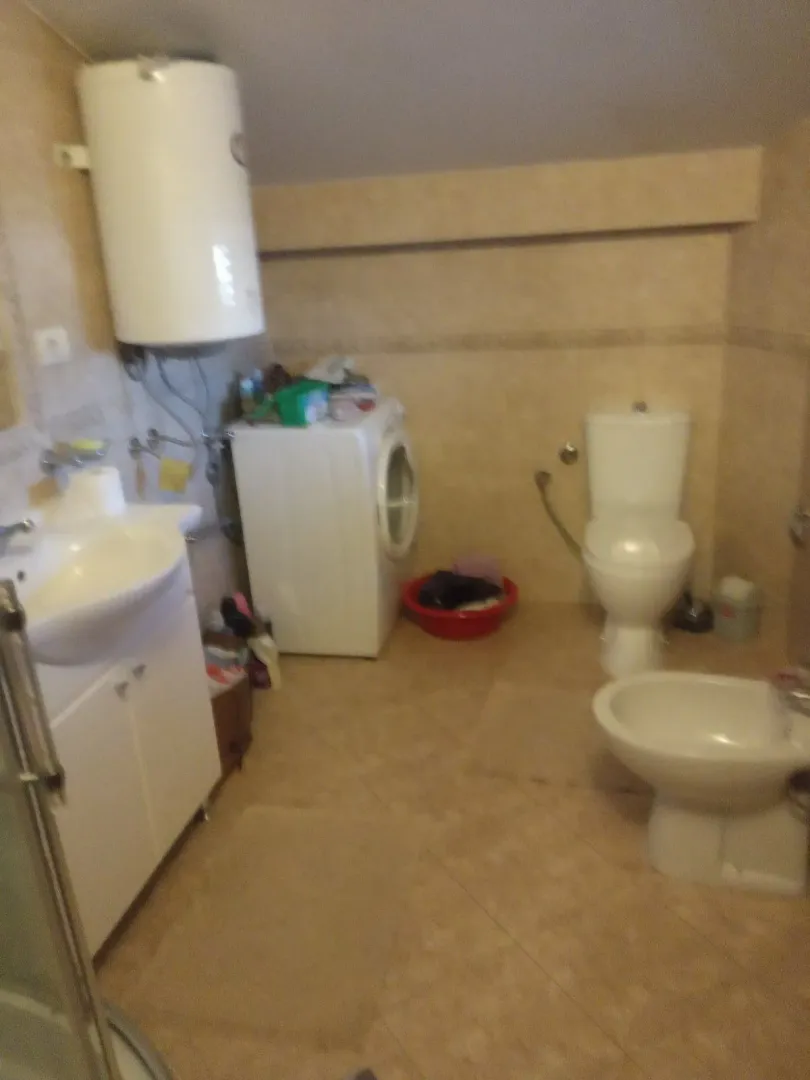 A bathroom featuring a bidet, toilet, and washing machine.
