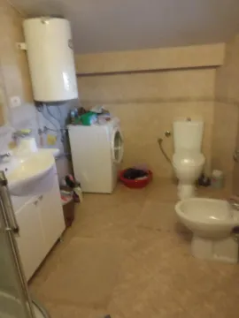 A bathroom featuring a bidet, toilet, and washing machine. - image 13