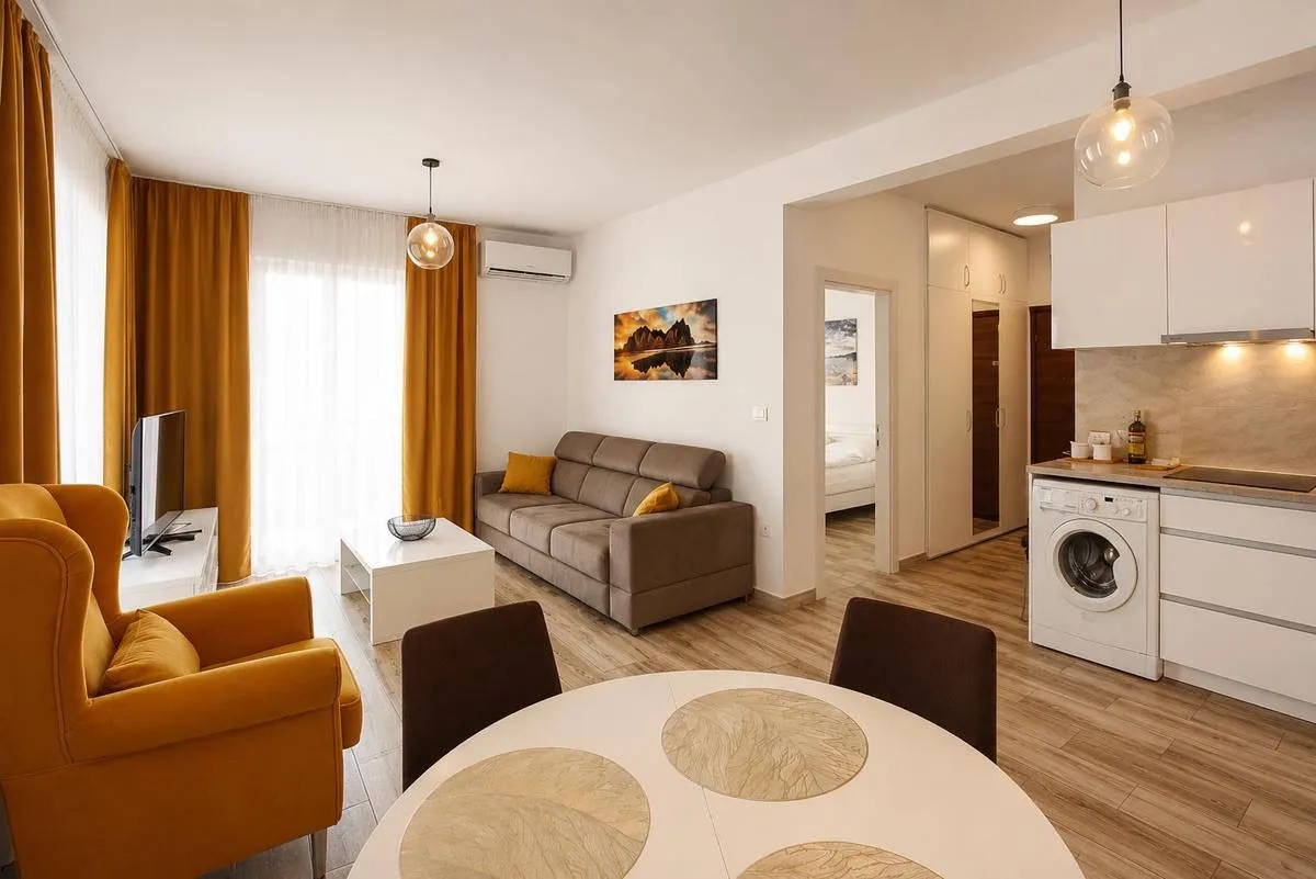 Living room with dining area and kitchen in light tones.