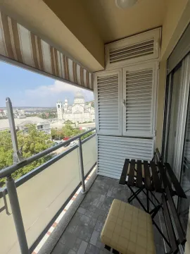 Balcony with a wooden table and chairs, offering a view of the temple. - image 4