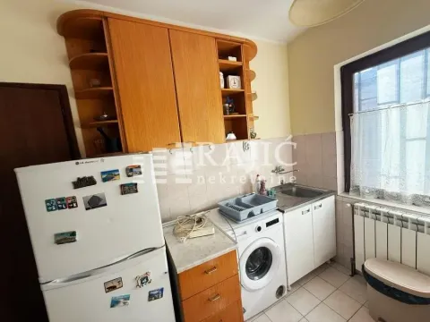 Smaller kitchen with wooden cabinets, refrigerator, and washing machine. - image 8