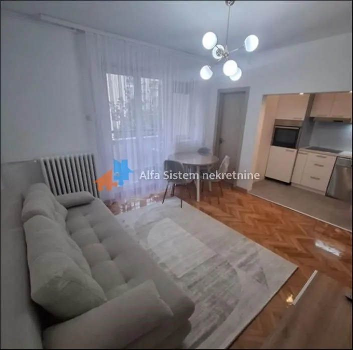 Living room with sofa and dining area, connected to the kitchen.