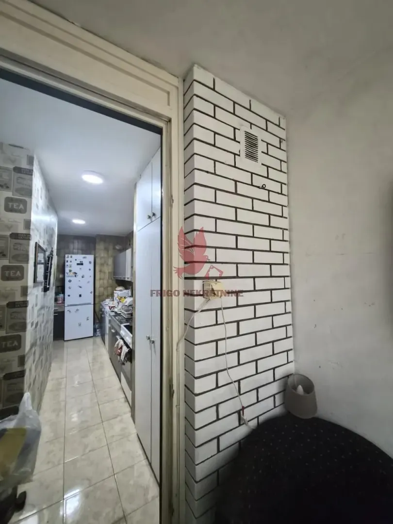 View from the enclosed balcony towards the kitchen and interior of the apartment.