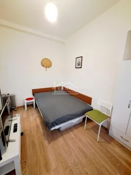 Manja spavaća soba sa krevetom, ormanom i televizorom. - image 5