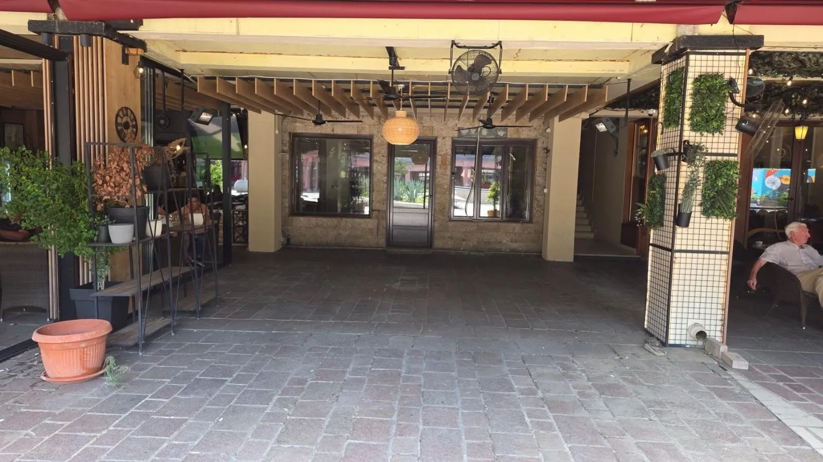 Exterior of a commercial space with a paved courtyard and awning.