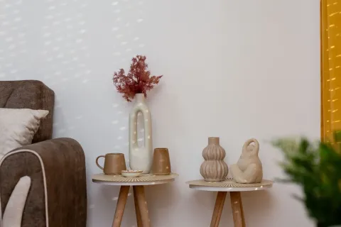 Detalj enterijera sa dekorativnim stočićima i vazama. - image 15