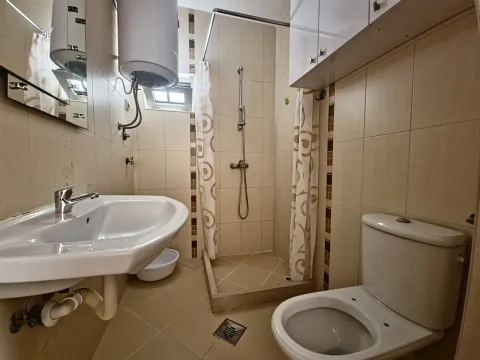 Kupatilo opremljeno umivaonikom, WC šoljom i tuš kabinom sa zavesom. - image 5