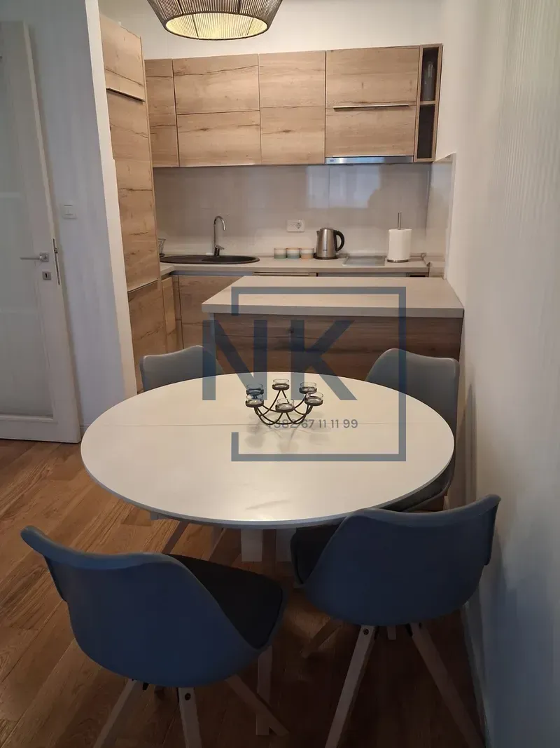 Kitchen with wooden cabinetry and a dining table with chairs.