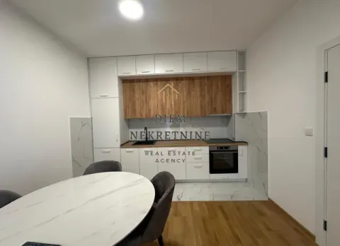 Modern kitchen with dining table and white cabinetry. - image 5