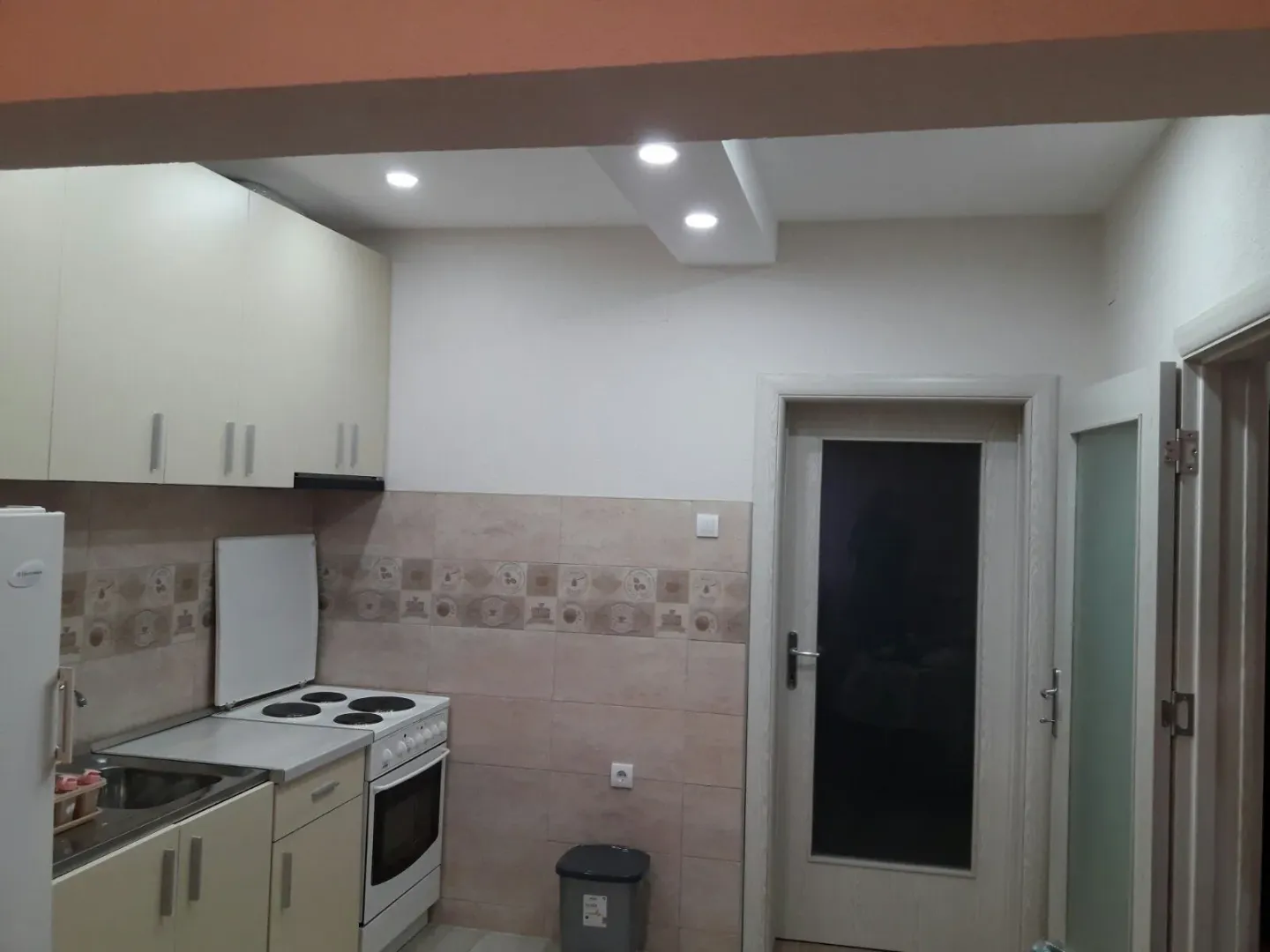 Kitchen with light-colored cabinets and an electric stove.