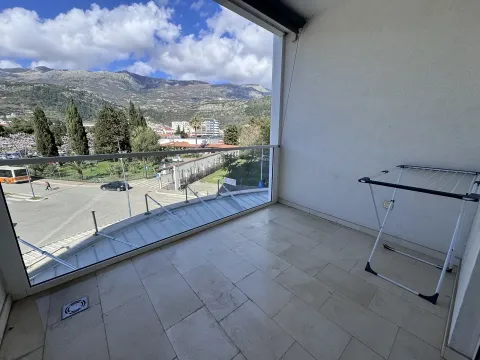 Natkriveni balkon sa staklenom ogradom i pogledom na planine i grad. - image 9