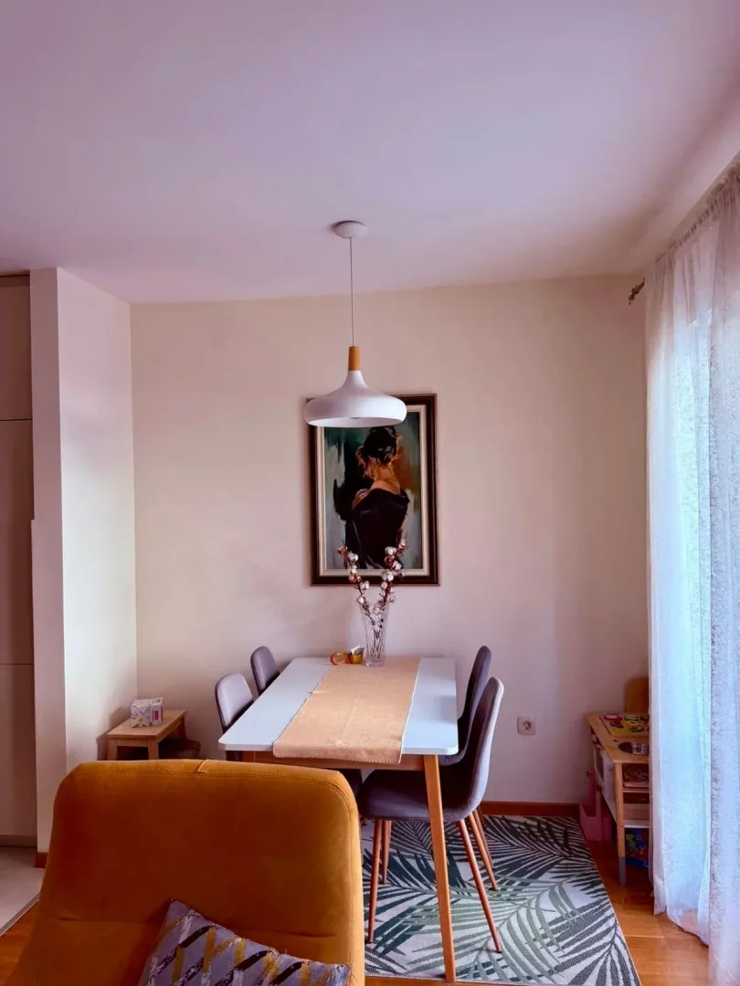 Dining area with a table, chairs, and a painting on the wall.
