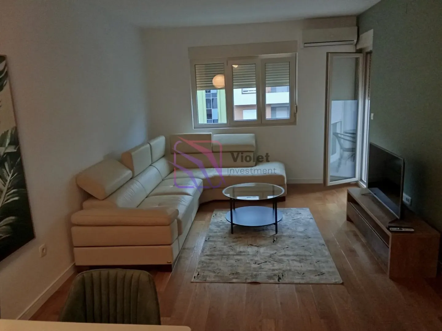 Living room with a sectional sofa, TV, and access to the terrace.