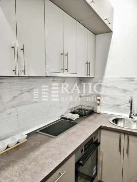 Modern kitchen with white cabinetry and built-in appliances. - image 5