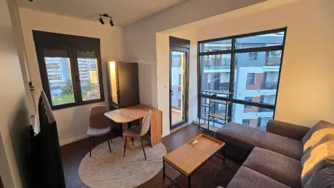 Living room with a sofa, dining table, and large windows. - image 15