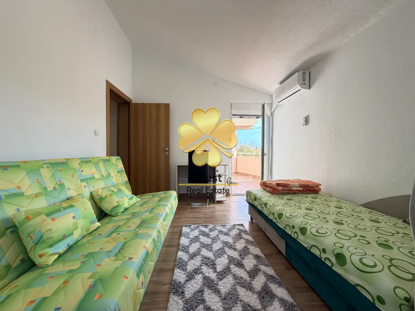 Living room with a bed, sofa, and access to the terrace.