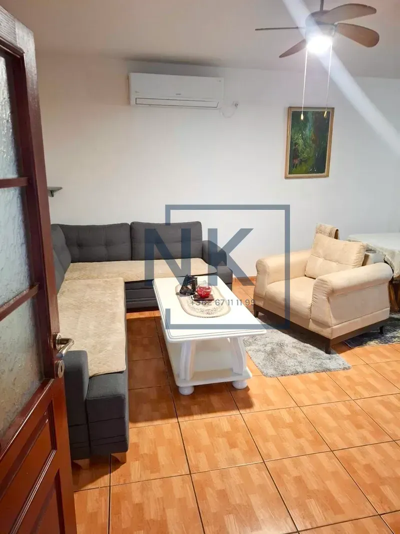 Living room with a seating set, coffee table, and air conditioning.
