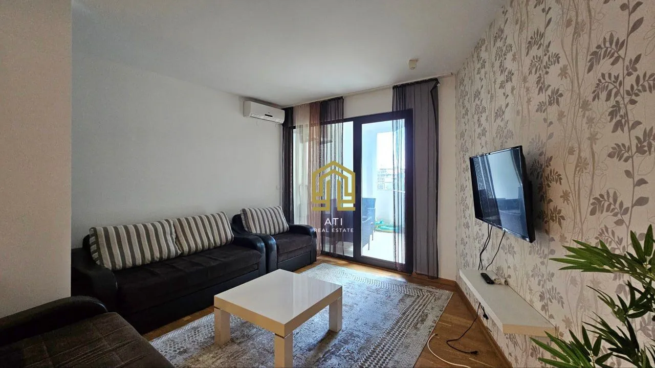 Living room with a sofa, TV, and access to the terrace.
