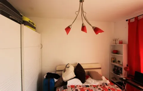 Spavaća soba sa bijelim garderoberom, krevetom i crvenim dekorativnim detaljima. - image 6