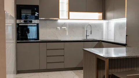 Modern kitchen with built-in oven, countertop, and sink. - image 10