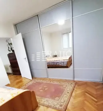 Bedroom with a large mirrored wardrobe and parquet flooring. - image 8