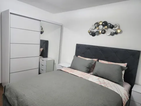 Namještena spavaća soba sa bračnim krevetom, bijelim ormarom i dekoracijom na zidu. - image 4