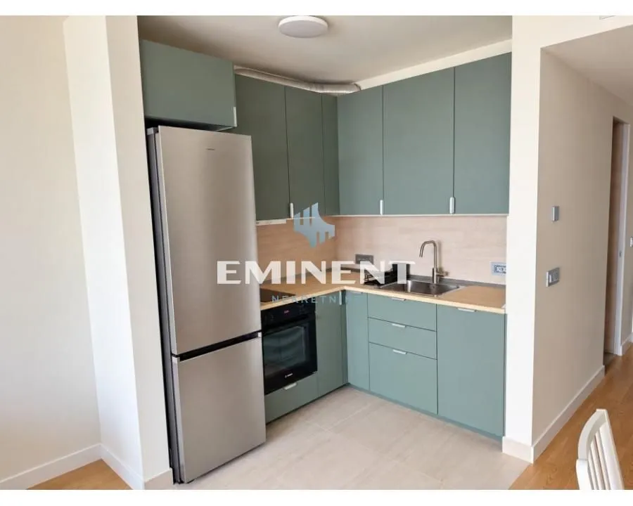Kitchen with green cabinets, built-in appliances, and a refrigerator.