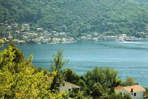 Pogled na more i okolno naselje sa zelenilom u prvom planu. - image 2