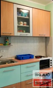 Pogled na dio kuhinje sa gornjim i donjim elementima, sudoperom i šporetom. - image 2