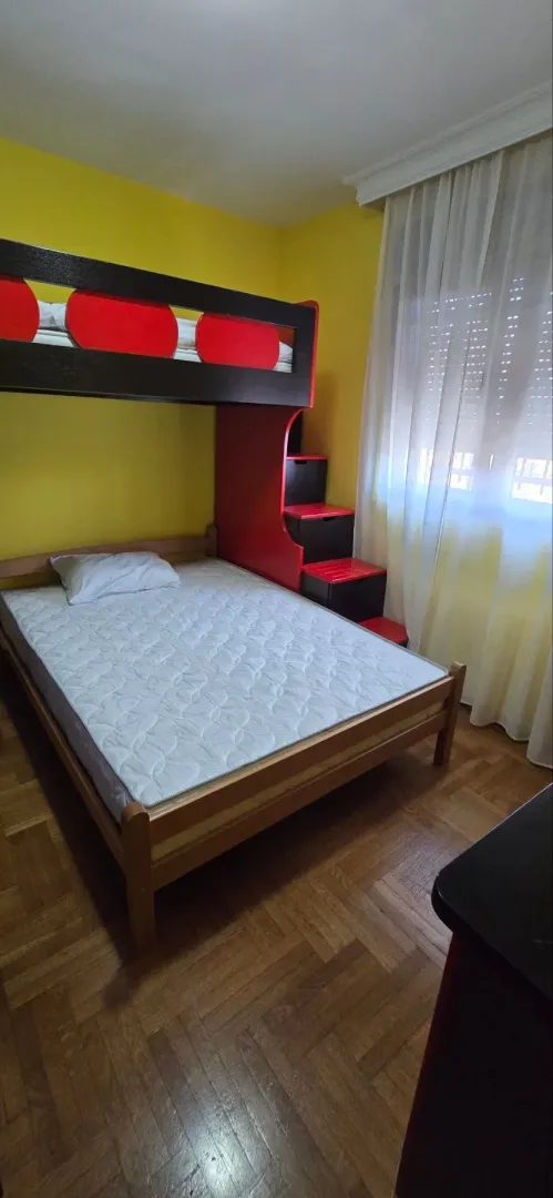 Dječija soba sa krevetom na sprat i žutim zidovima.