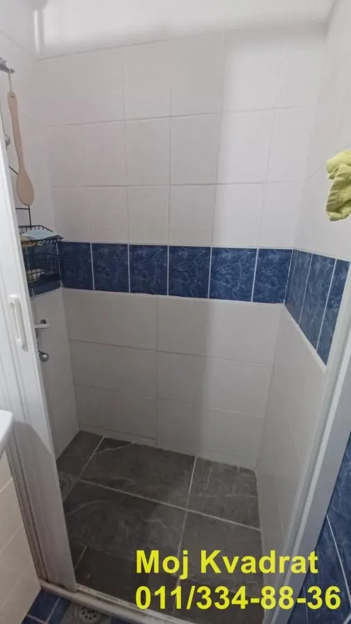 Pogled na tuš kabinu obloženu keramičkim pločicama u kupatilu.