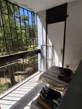 Manji natkriveni balkon sa metalnom ogradom i stolom. - image 7