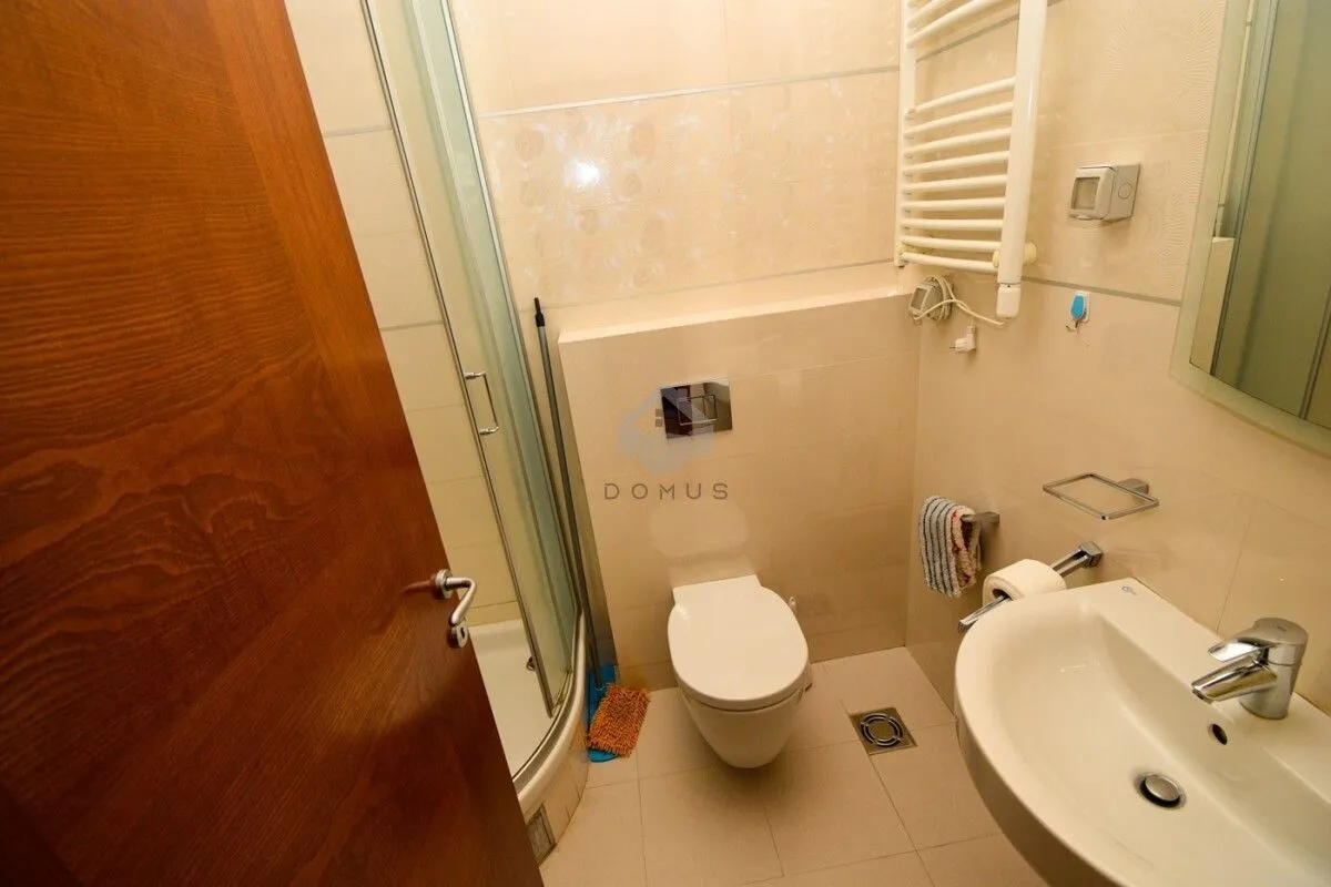 Compact bathroom with a shower cabin, washbasin, and toilet.