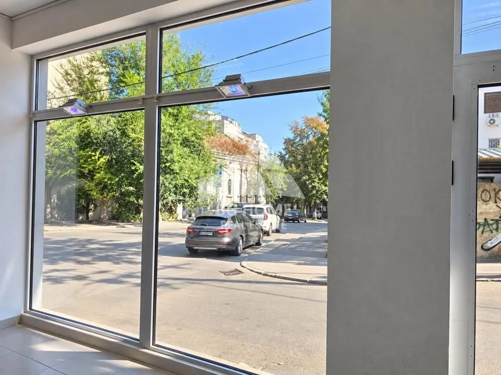 View from the interior through a large storefront onto the city street.