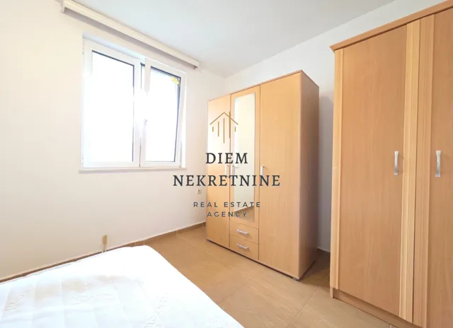Furnished bedroom with wardrobes and a window.