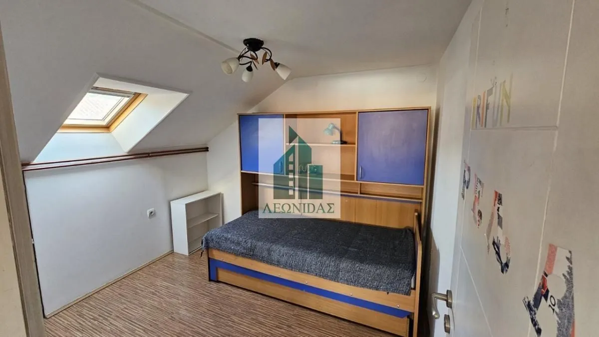 Children's attic bedroom with a bed and a skylight.