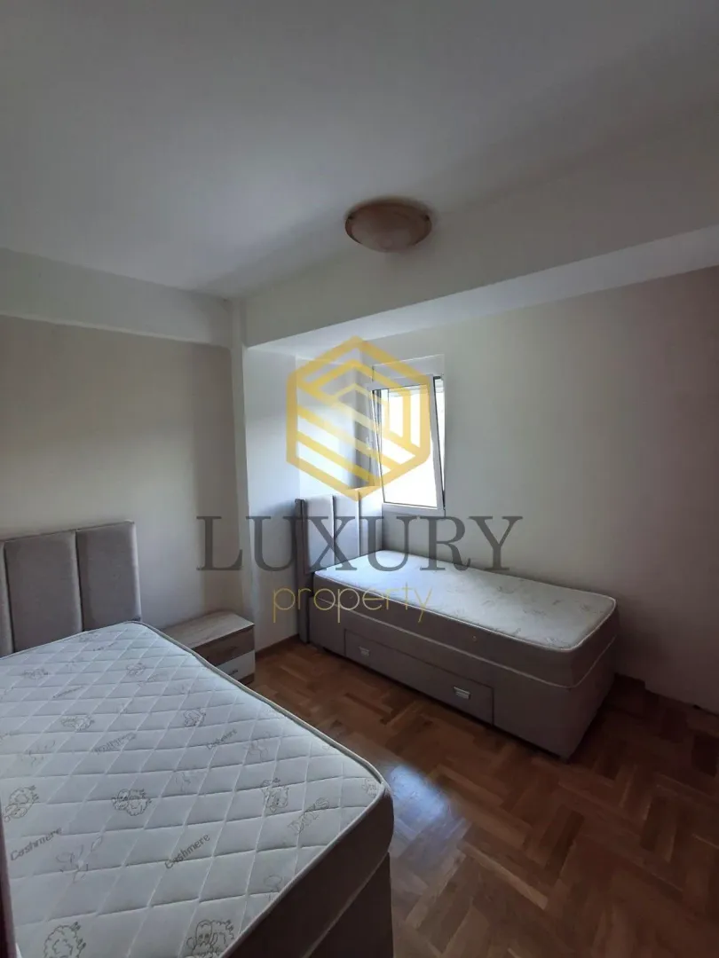 Bedroom with two beds and wooden flooring.