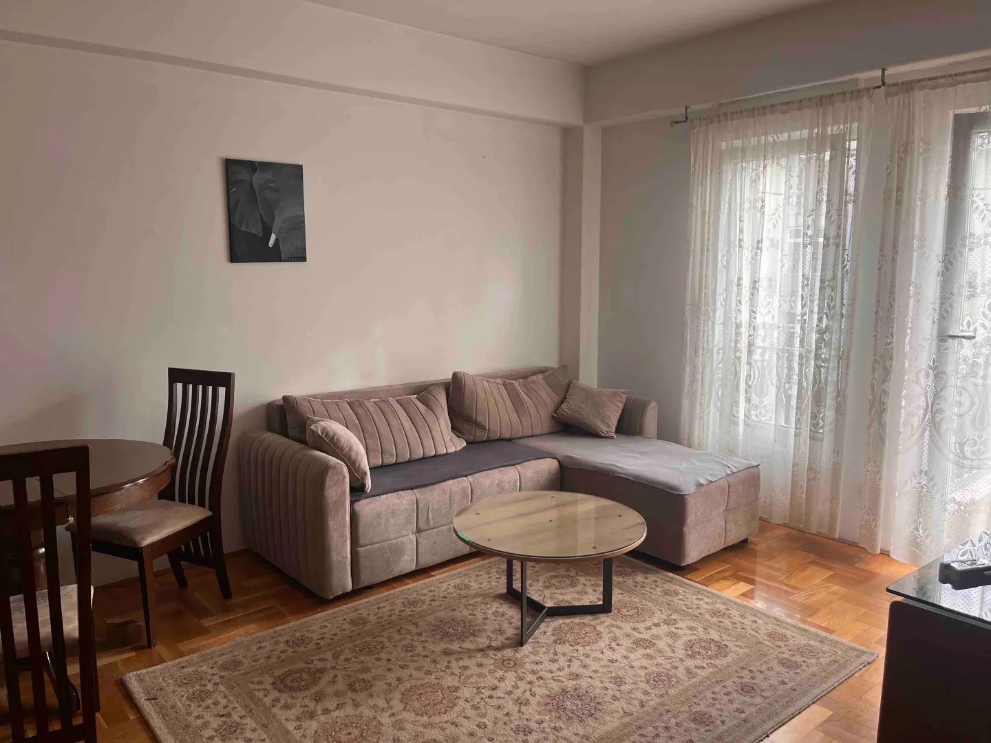 Living room with a sectional sofa, coffee table, and dining table.