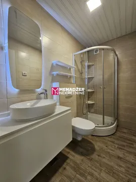 Moderno opremljeno kupatilo sa tuš kabinom i umivaonikom. - image 9