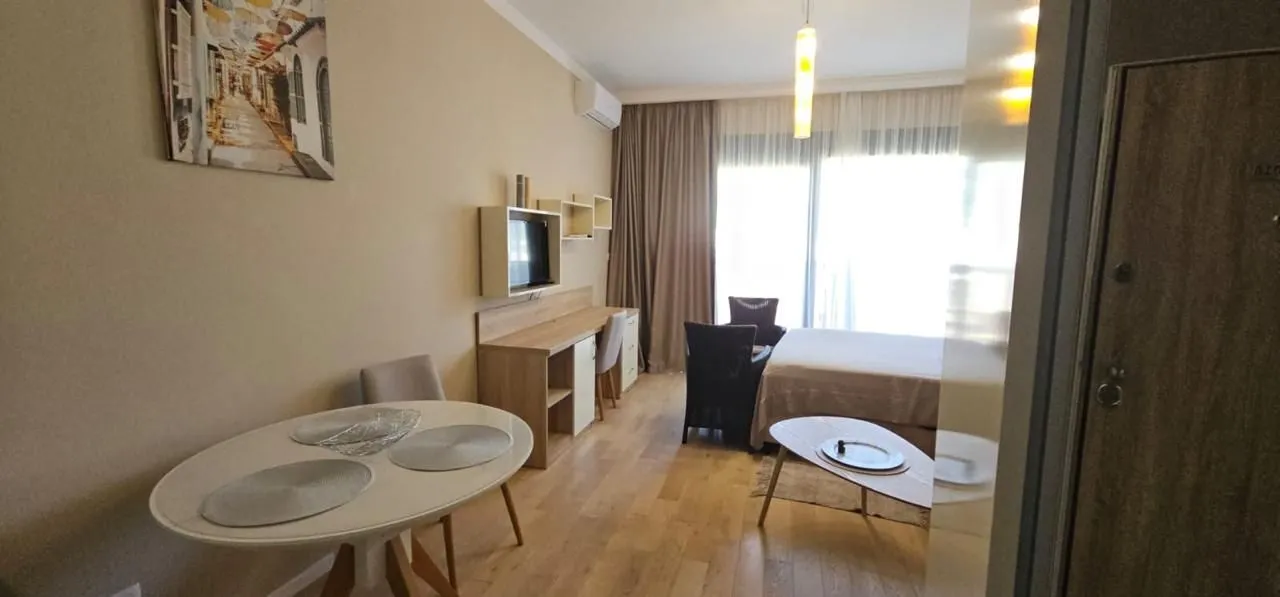 Living room with a dining table and a bed.