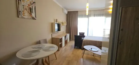 Living room with a dining table and a bed. - image 3