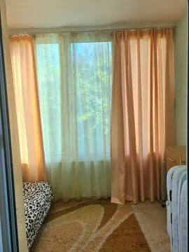 Manja spavaća soba sa prozorom, zavesama i krevetom. - image 2