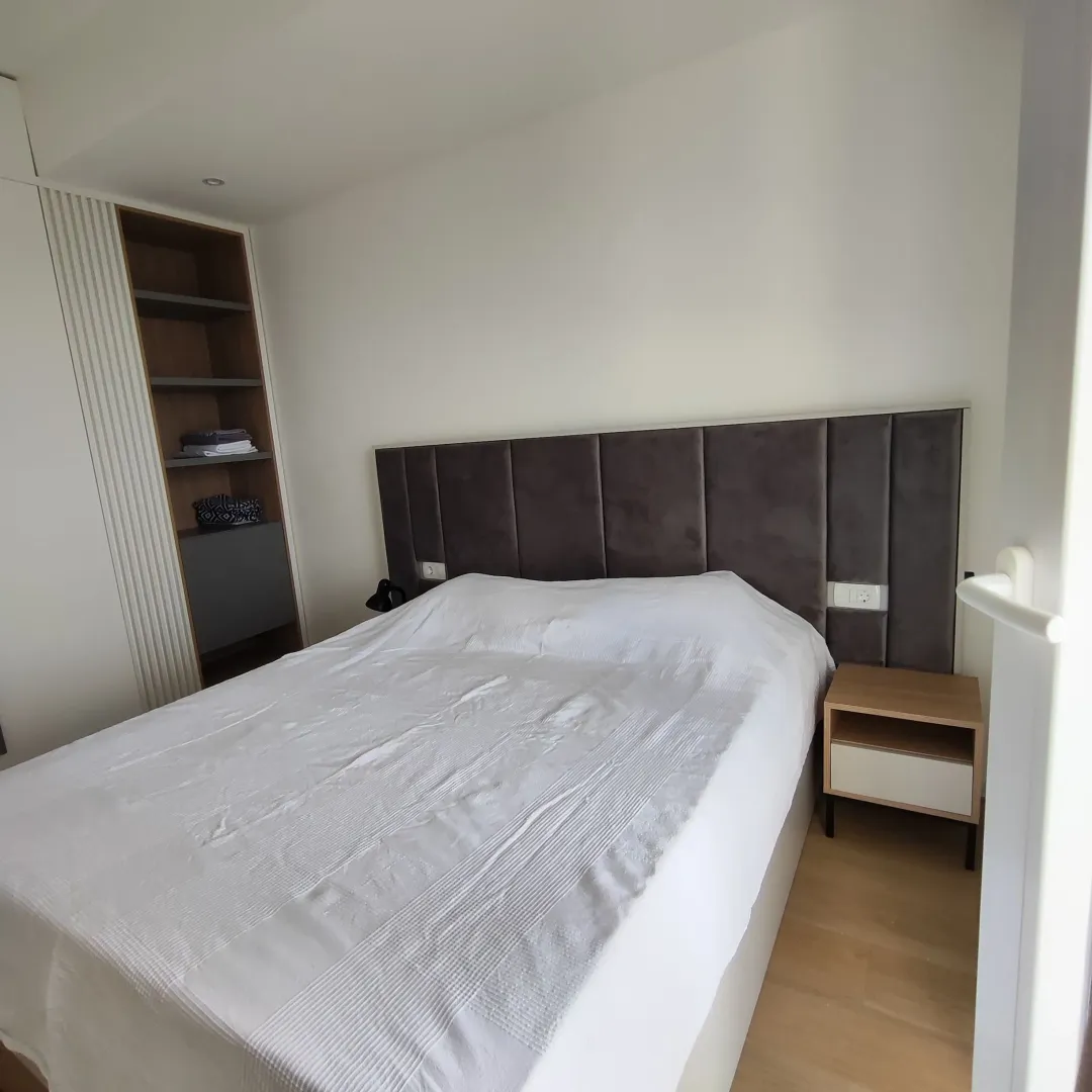 Moderna spavaća soba sa bračnim krevetom, uzglavljem i ugradnim plakarom.