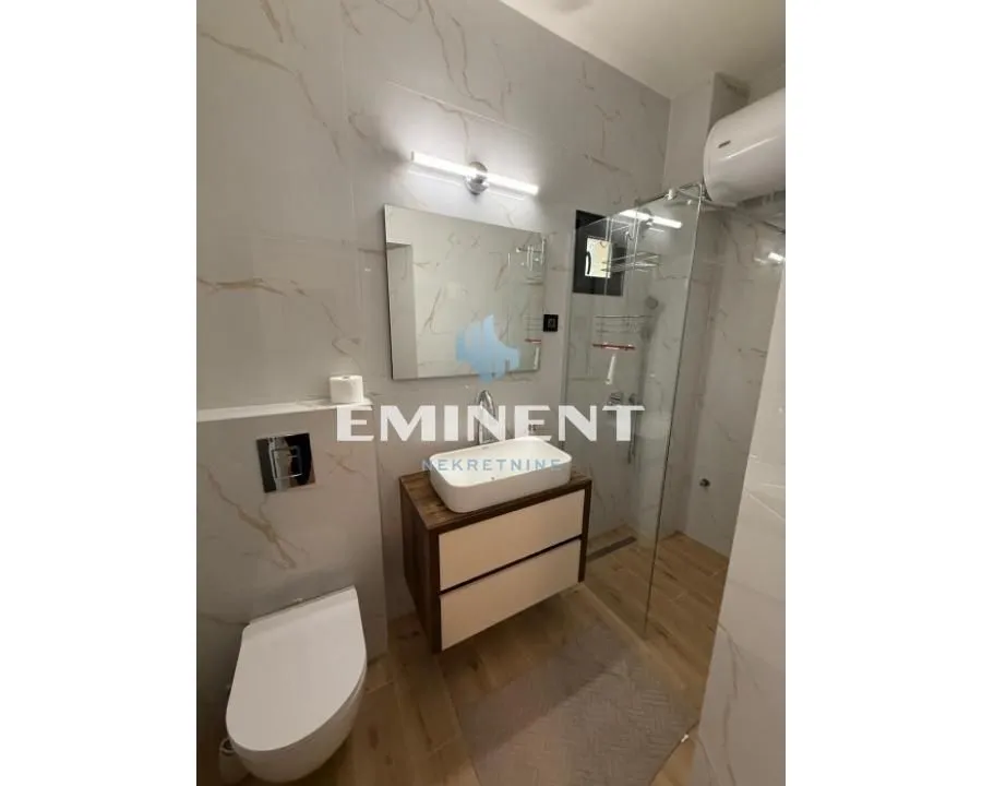 A modern equipped bathroom with a walk-in shower and a washbasin.
