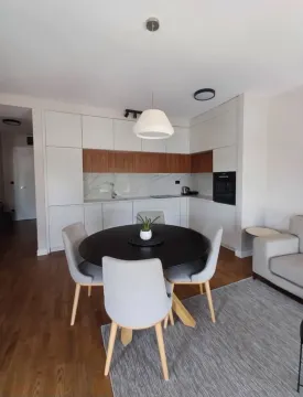 Modern kitchen with dining area and built-in appliances. - image 5